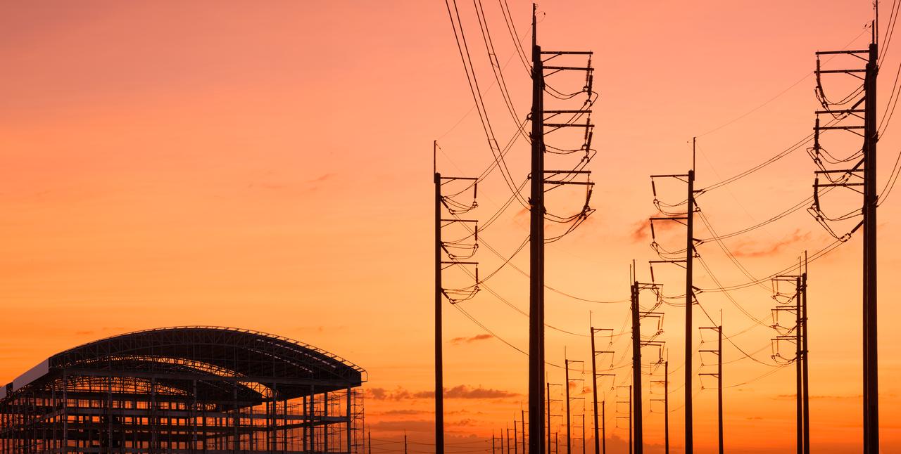 Power lines and a new building under construction at golden hour