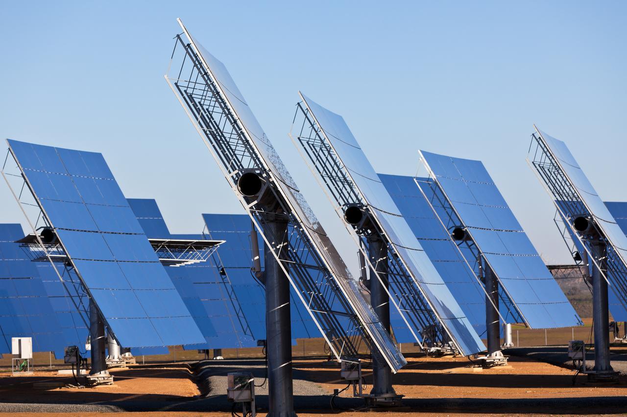 Rows of solar panels reflecting a blue sky